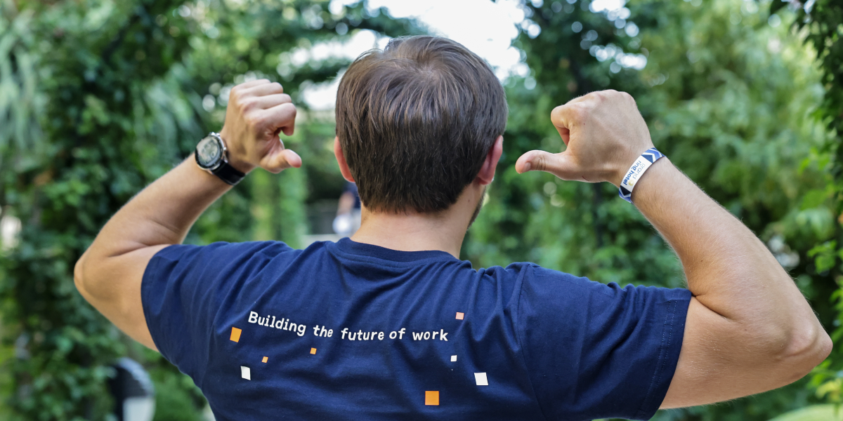 man pointing to the back of his shirt, building the future of work